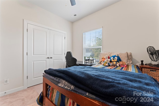 bedroom featuring ceiling fan, light colored carpet, and a closet