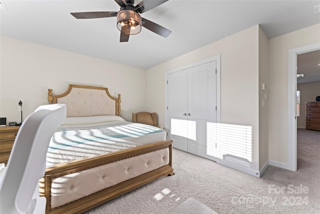 carpeted bedroom with ceiling fan and a closet