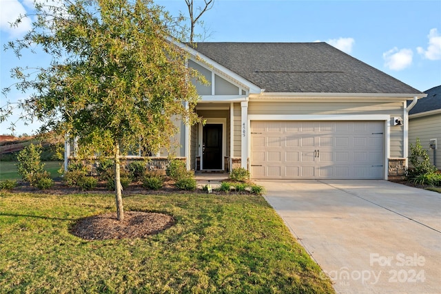 view of front of house featuring a garage and a front lawn