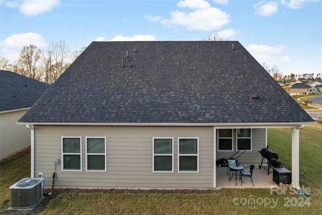 rear view of house with a lawn, a patio area, and central air condition unit