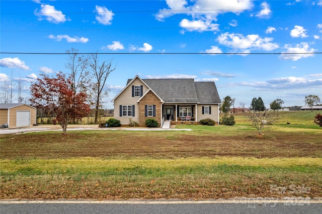 view of front of house featuring a garage, an outdoor structure, a front yard, and covered porch