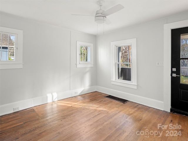 spare room featuring a wealth of natural light, hardwood / wood-style flooring, and ceiling fan