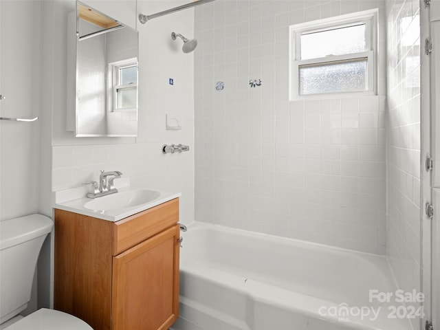 full bathroom featuring vanity, toilet, backsplash, and tiled shower / bath combo