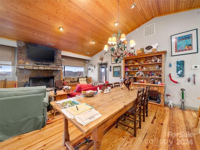 dining area featuring wooden ceiling, a chandelier, a stone fireplace, lofted ceiling, and light wood-type flooring