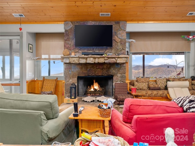 living room with a fireplace, a healthy amount of sunlight, and wooden ceiling