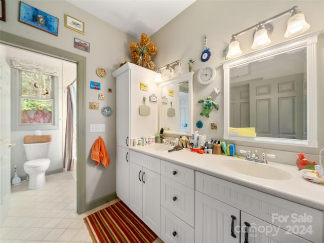 bathroom with tile patterned flooring, vanity, and toilet