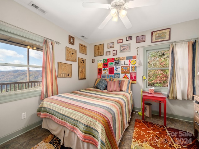 bedroom featuring multiple windows, a mountain view, and ceiling fan