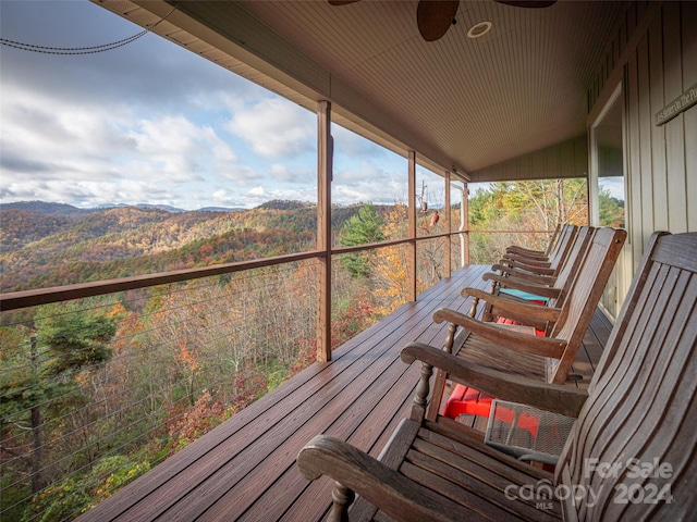 sunroom featuring a mountain view, ceiling fan, and vaulted ceiling