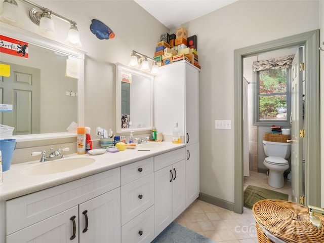 bathroom featuring toilet, vanity, and tile patterned floors