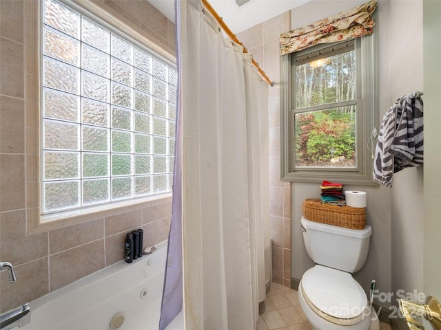 bathroom with toilet, a wealth of natural light, and tile patterned floors