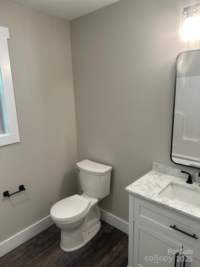 bathroom with vanity, hardwood / wood-style flooring, and toilet