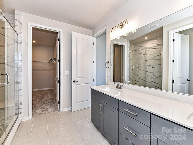 bathroom featuring tile patterned flooring, vanity, and walk in shower