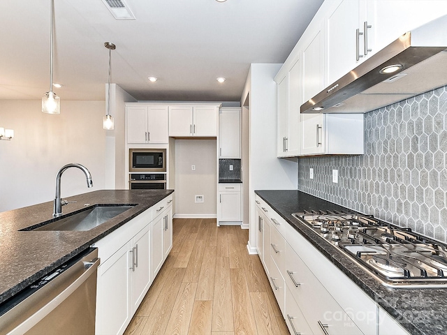 kitchen with sink, hanging light fixtures, stainless steel appliances, white cabinets, and light wood-type flooring