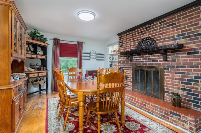 dining room featuring light wood-type flooring and a fireplace