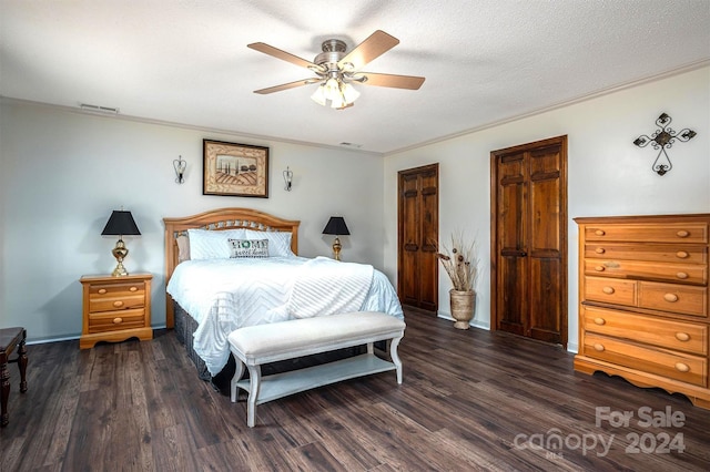 bedroom with a textured ceiling, dark hardwood / wood-style flooring, and ceiling fan