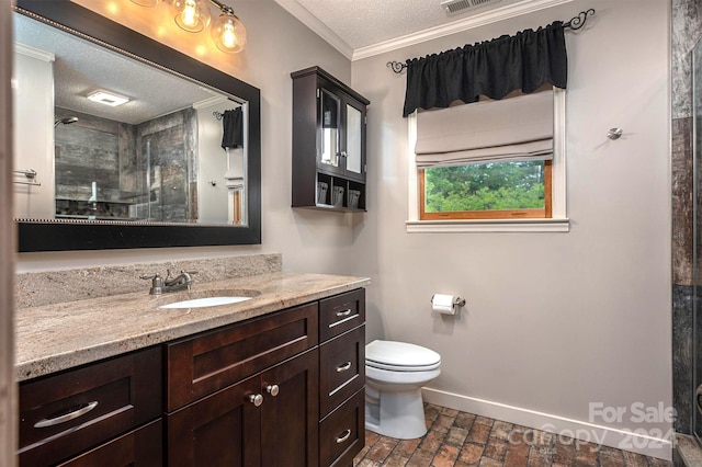 bathroom with toilet, a textured ceiling, ornamental molding, vanity, and walk in shower