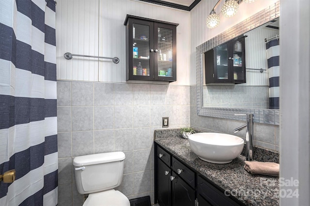 bathroom with toilet, vanity, tile walls, and ornamental molding