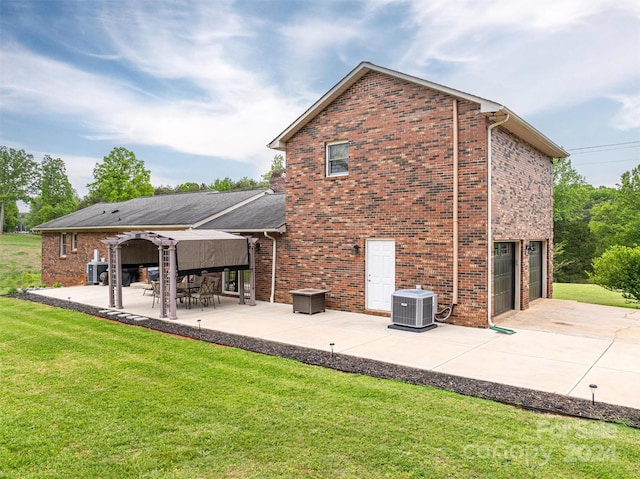 back of house with a garage, a patio, central AC, and a yard