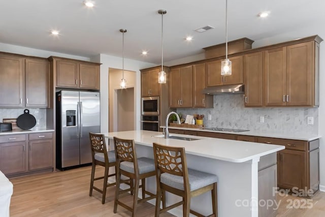 kitchen with decorative backsplash, appliances with stainless steel finishes, pendant lighting, and sink