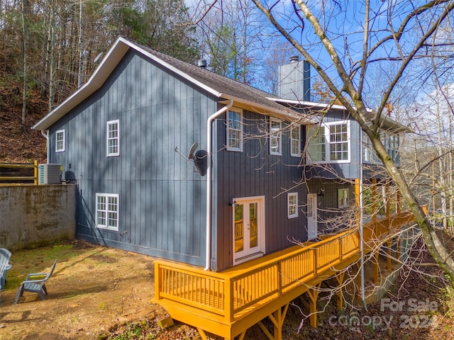 rear view of house featuring french doors, a wooden deck, and central air condition unit