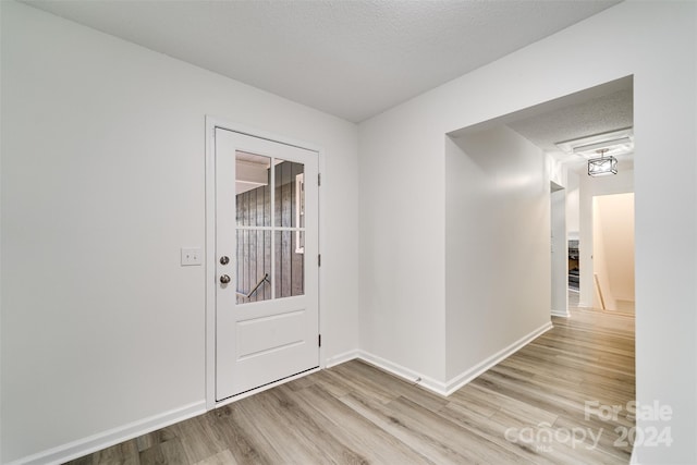 entrance foyer featuring a textured ceiling and light hardwood / wood-style floors