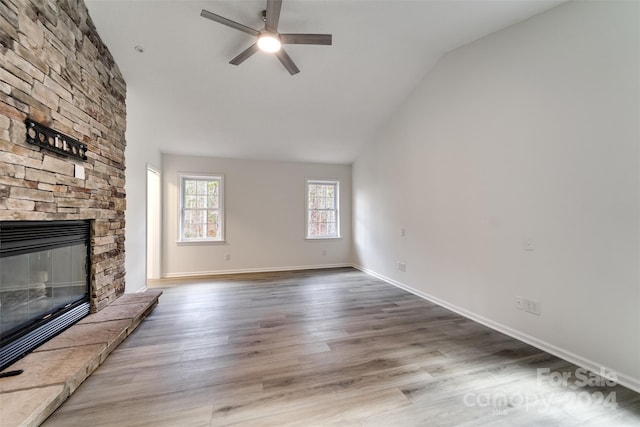 unfurnished living room with a fireplace, light hardwood / wood-style floors, ceiling fan, and lofted ceiling