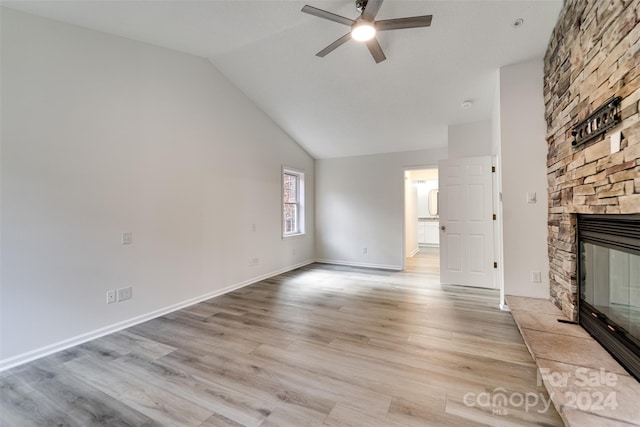 unfurnished living room with a fireplace, light hardwood / wood-style floors, high vaulted ceiling, and ceiling fan