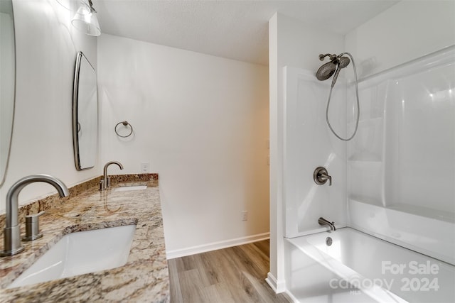 bathroom with vanity, hardwood / wood-style floors, a textured ceiling, and shower / bathtub combination