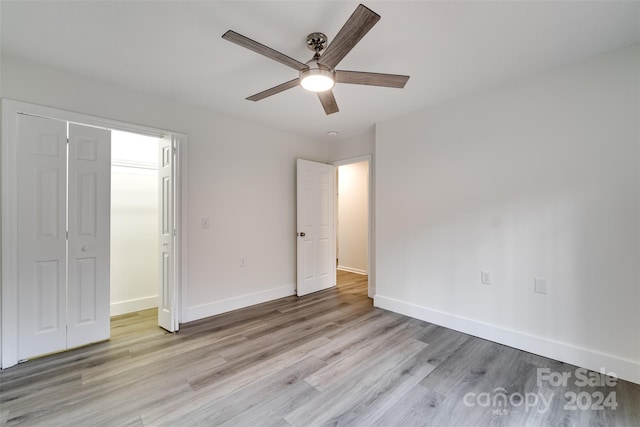 unfurnished bedroom with a closet, light hardwood / wood-style floors, and ceiling fan