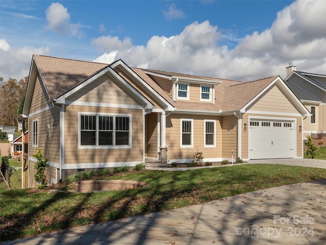 craftsman-style home featuring a garage and a front lawn