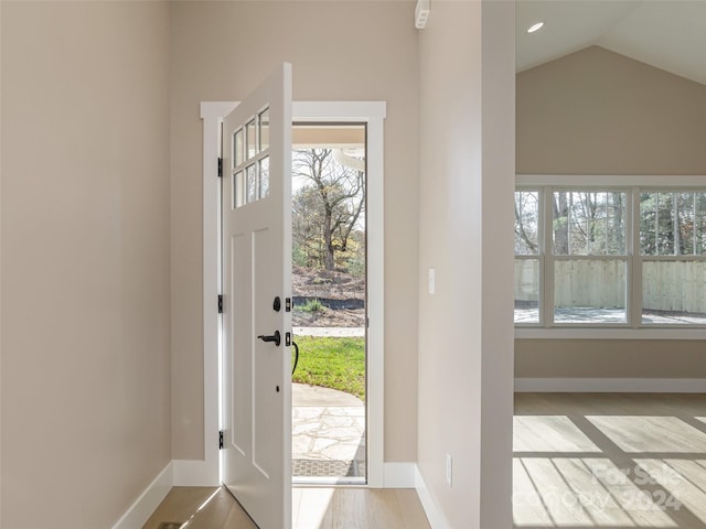 entrance foyer with light wood-type flooring and vaulted ceiling