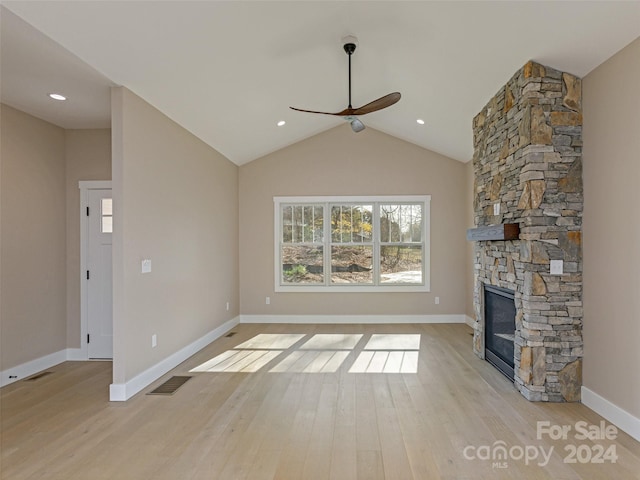 unfurnished living room featuring a fireplace, light hardwood / wood-style floors, lofted ceiling, and ceiling fan