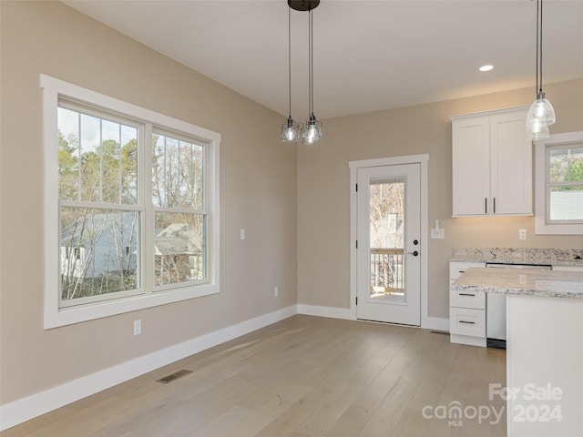 unfurnished dining area with light wood-type flooring and a wealth of natural light