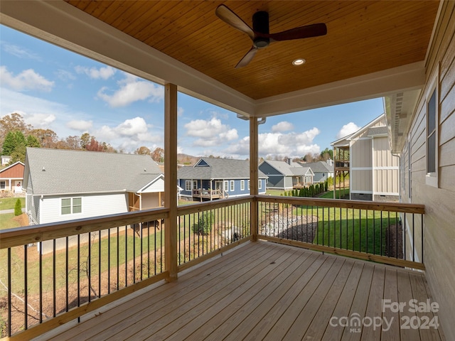 wooden deck with a lawn and ceiling fan