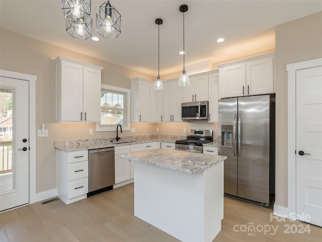 kitchen with stainless steel appliances, a wealth of natural light, hanging light fixtures, and white cabinetry