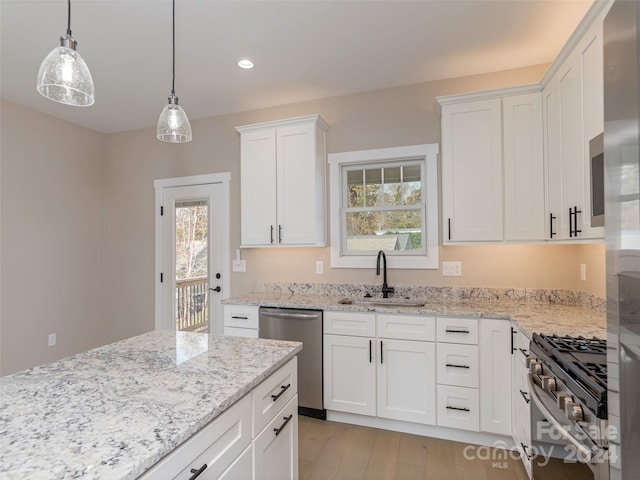 kitchen with white cabinetry, a wealth of natural light, appliances with stainless steel finishes, and light hardwood / wood-style floors