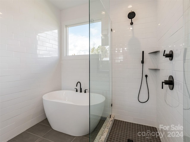 bathroom with shower with separate bathtub, tile walls, and tile patterned floors