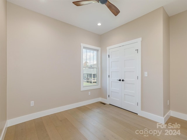 unfurnished bedroom with light hardwood / wood-style flooring, ceiling fan, and a closet