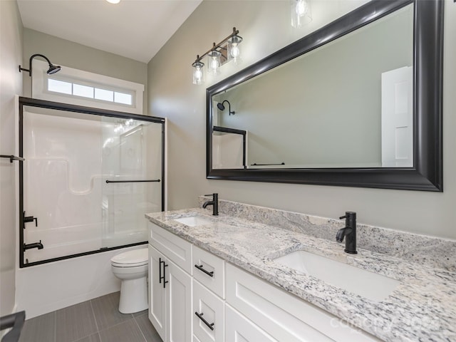 full bathroom featuring shower / bath combination with glass door, toilet, and vanity