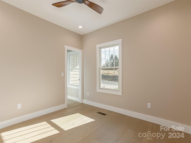 empty room with ceiling fan and light hardwood / wood-style floors