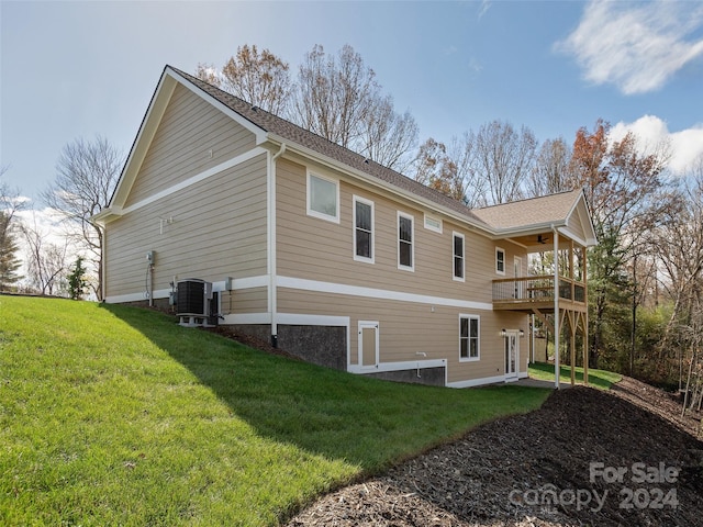 back of house featuring central AC unit and a yard