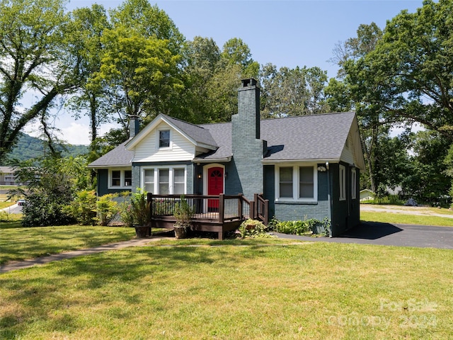 view of front of property with a front yard and a wooden deck