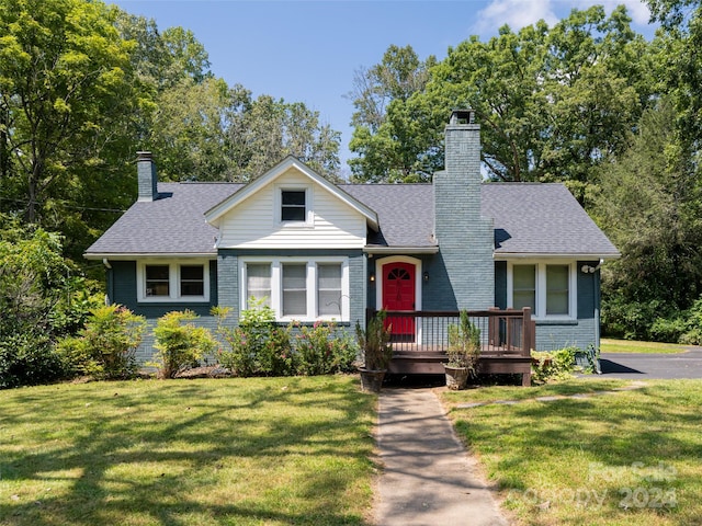 view of front of home featuring a wooden deck and a front yard