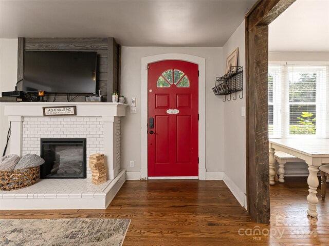 foyer with dark wood-type flooring and a fireplace