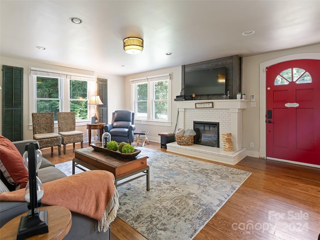 living room with hardwood / wood-style flooring and a tile fireplace