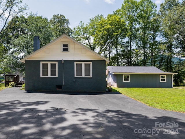 view of side of property featuring a deck and a lawn