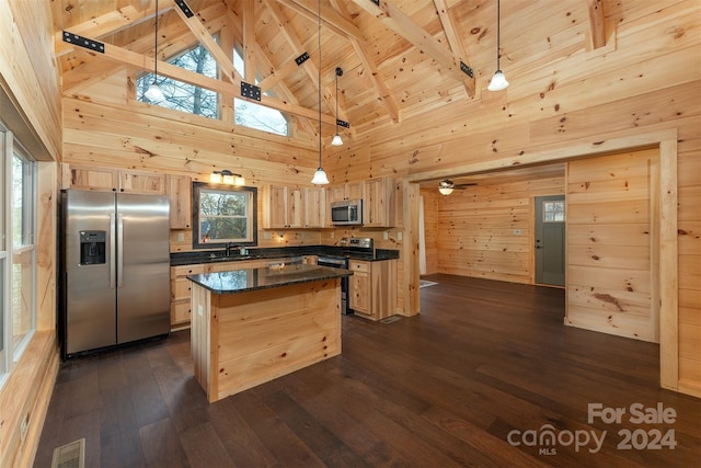 kitchen with appliances with stainless steel finishes, dark hardwood / wood-style flooring, a kitchen island, and hanging light fixtures