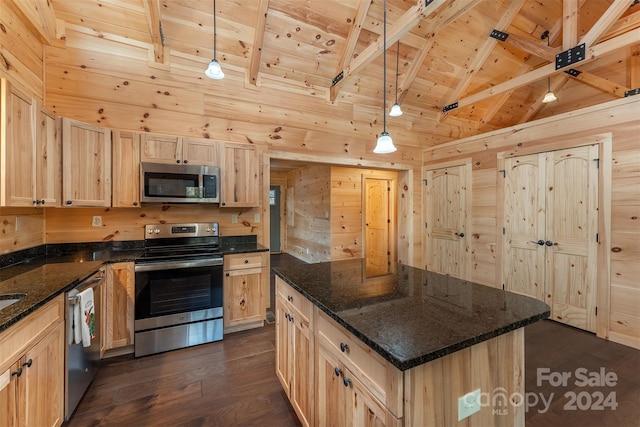 kitchen featuring beamed ceiling, appliances with stainless steel finishes, hanging light fixtures, and dark wood-type flooring