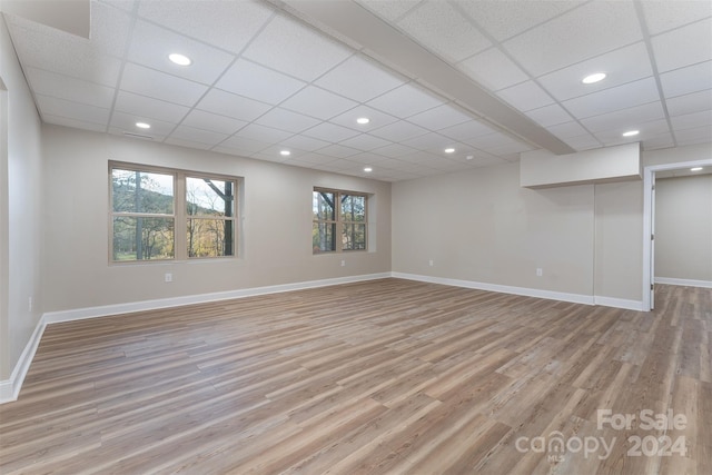 basement with light wood-type flooring and a drop ceiling