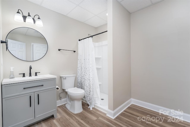 bathroom with a paneled ceiling, toilet, hardwood / wood-style floors, and walk in shower